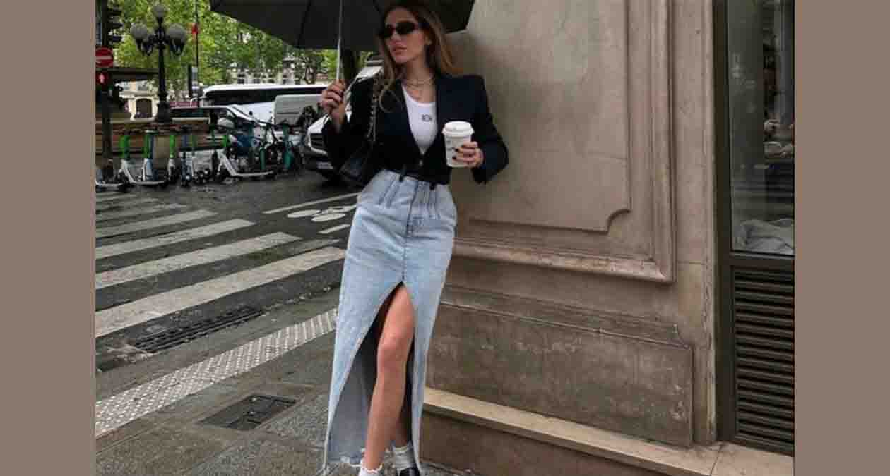 دختری با دامن جین بلند به رنگ آبی روشن و کت مشکی